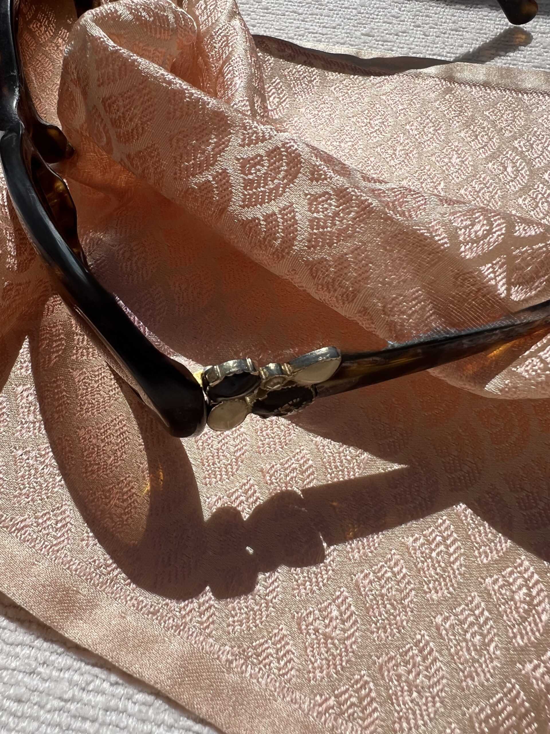 Lunettes Chanel posées sur un Carré de poche précieux Tohora 26 cm en soie de mûrier couleur pêche saumonée avec motifs de feuilles texturées en relief tissées main