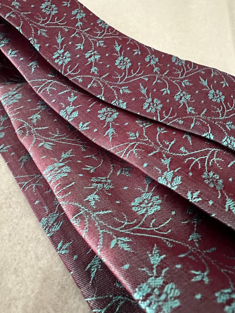Twilly en soie de mûrier Tohora 80x5cm tissé main bicolore rouge grenat et fleurs turquoise en relief